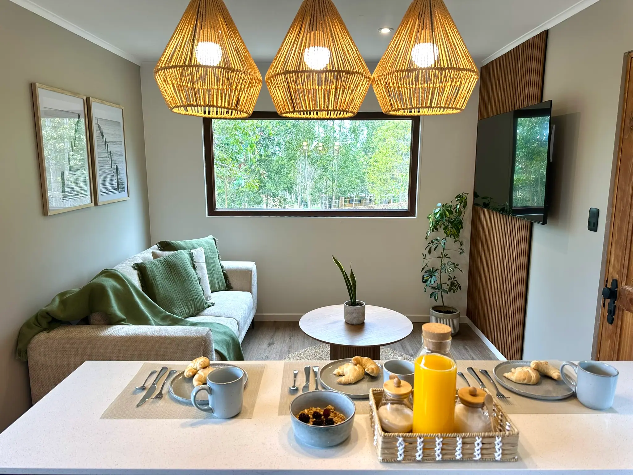Desayuno servido en la mesa de la cabaña, con jugo natural, pan y café