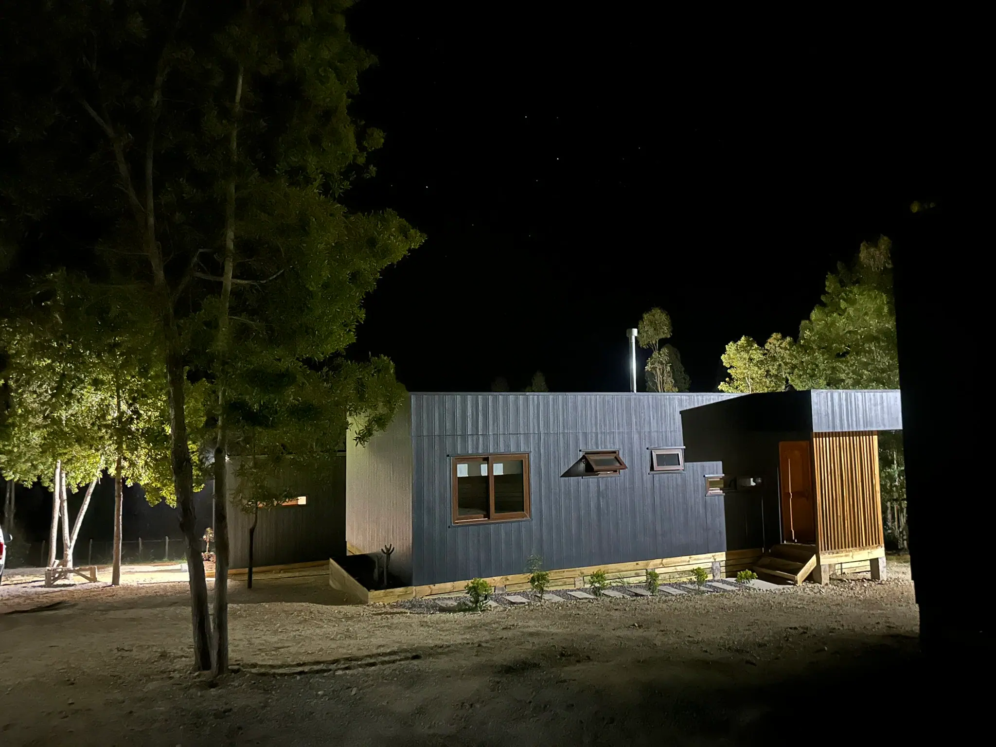 Cabaña iluminada de noche en el bosque